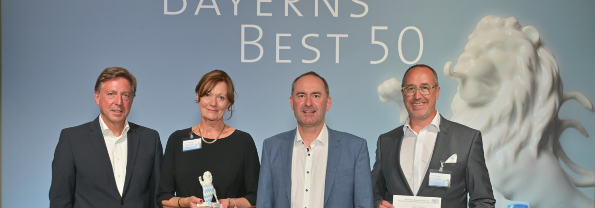 Ernst Steuger, Geschäftsführer der Nürnberger Wach- und Schließgesellschaft (NWS), und Ellen Heutling, Prokuristin und Leiterin Marketing und Vertrieb, nehmen die Auszeichnung "Bayerns Best 50" von Bayerns Wirtschaftsminister Hubert Aiwanger entgegen.